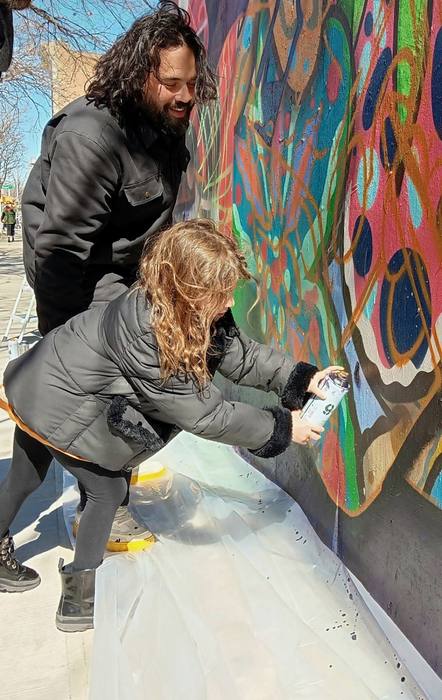 Child engaging with a community mural painted by DREPS in Miami