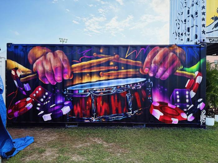 Miami muralist DREPS painting a drumline mural in vivid color